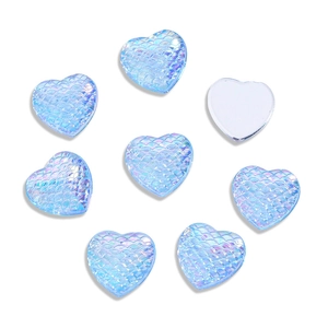 Macro view of blue heart cabochons with AB coating and mermaid scale texture for DIY crafts
