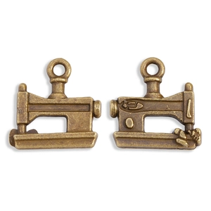 Detail of vintage bronze sewing machine charm with intricate textures for DIY jewelry