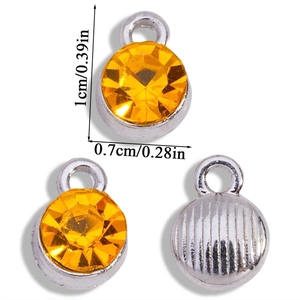 Three silver alloy birthstone pendants with orange rhinestones and 1cm size markers