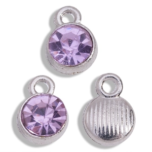 Detailed macro view of three purple round birthstone charms with silver-toned metal backing