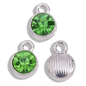 Detail view of round green rhinestone charms with silver metal base for jewelry making