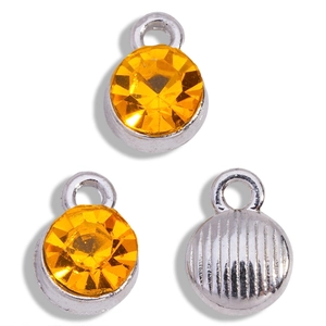Detail of yellow rhinestone charms with silver metal base and striped back for DIY jewelry