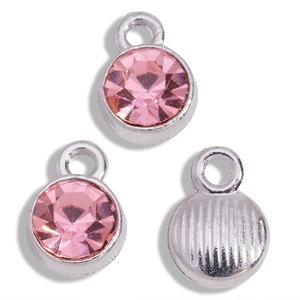 Close-up of pink crystal birthstone pendants with silver base and textured metal back