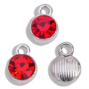 Detail of red birthstone pendants with silver metal base and textured back for DIY jewelry