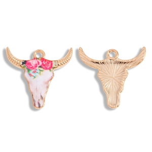 Gedetailleerd beeld van bohemien stierenschedel hanger met bloemen en gouden hoorns