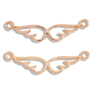 Detailed macro view of angel wing alloy connectors with rose gold plating for DIY jewelry