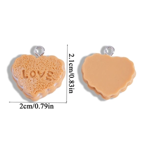 Macro view of heart-shaped biscuit pendant with LOVE embossing and silver hook detail