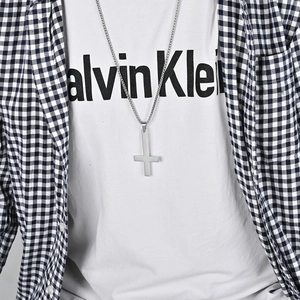 Polished stainless steel upside down St. Peter cross necklace worn with casual streetwear style