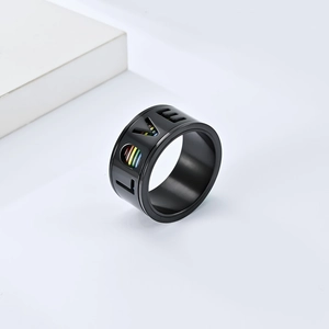Gros plan d'une bague en acier noir avec découpe LOVE et bandes arc-en-ciel de la pride