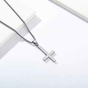 Detailaufnahme eines silbernen Petruskreuz-Anhängers an einer Boxkette auf Blöcken