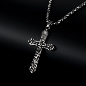 Macro view of vintage silver crucifix pendant with gothic carvings on black background