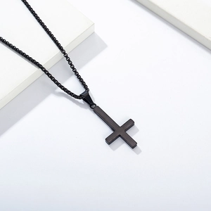 Makroaufnahme des mattschwarzen Edelstahl-Inverted-Cross-Anhängers auf Geoblöcken