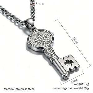 Macro detail of stainless steel Saint Benedict key pendant with engraved religious medal