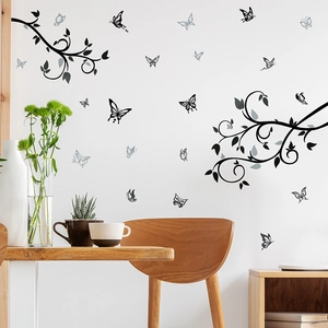Detail of black vine and butterfly wall stickers on a clean white living room wall