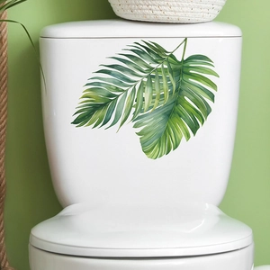 Close-up of tropical green palm leaf waterproof stickers on a white ceramic toilet tank