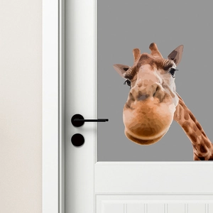 Detail of a 3D effect giraffe door sticker on a modern white door in a home setting