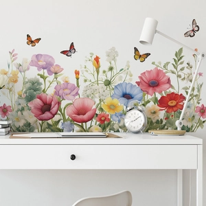 Detail showing colorful floral and butterfly wall decals on a minimalist white office desk setup