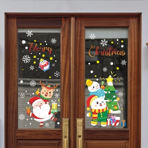 Close-up of Merry Christmas window stickers featuring Santa Claus and reindeer on a glass door