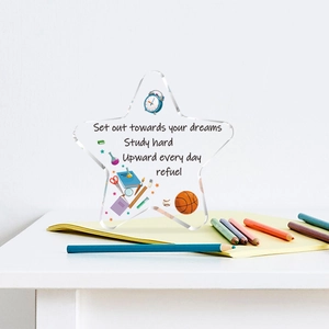 Close-up of star-shaped acrylic desk plaque with motivational quotes and vibrant stationery