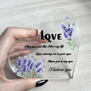 Macro shot of heart-shaped acrylic plaque with lavender print and romantic English text