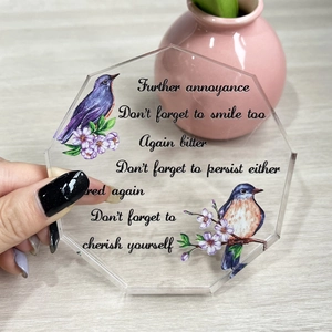 Detailed macro view of octagonal clear acrylic plaque with birds and floral print