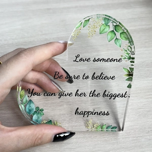 Detail eines Herz-Acryl-Geschenks mit grünen Blättern und inspirierendem Spruch