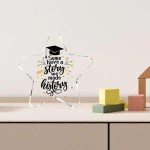 Targa di laurea a stella in acrilico con citazione e stelle dorate su tavolo in legno