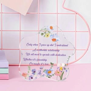 Macro shot of clear acrylic flower ornament featuring colorful floral patterns and quotes