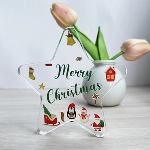 Macro detail of clear acrylic star ornament with Merry Christmas festive illustrations
