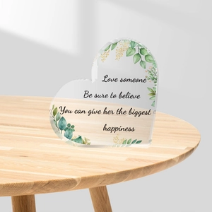 Herzförmiger Acryl-Tischaufsteller mit Blumendruck und Spruch auf Holzoberfläche