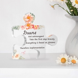 Clear puzzle acrylic ornament with orange floral print and inspirational quote on desk