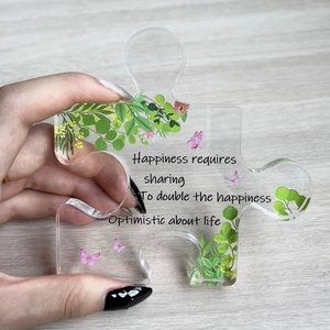 Detail eines transparenten Acryl-Puzzlestücks mit Blumenmustern und motivierendem Text