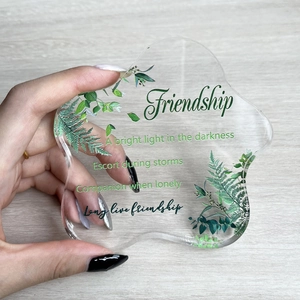 Handheld wave-shaped acrylic plaque featuring clear botanical leaf prints and friendship quotes