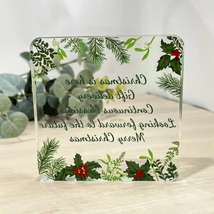 Square transparent acrylic Christmas ornament featuring pine leaves and red berries