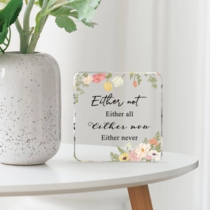 Square acrylic desktop plaque with floral border and motivational quote on white table