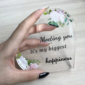 Acrylic heart ornament with pink floral design and emotional quote on wooden background