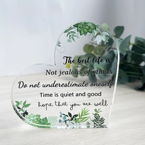 Macro view of heart-shaped acrylic ornament with green succulent patterns and quotes
