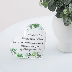 Heart-shaped acrylic plaque with succulent print and motivational quote on white desk