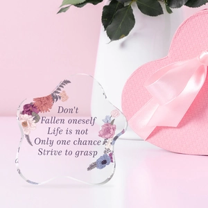 Vista macro di decorazione in acrilico floreale con citazioni e scatola regalo rosa