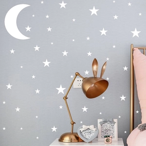 Detailaufnahme weißer Wandaufkleber mit Mond und Sternen auf Schlafzimmer-Tapete