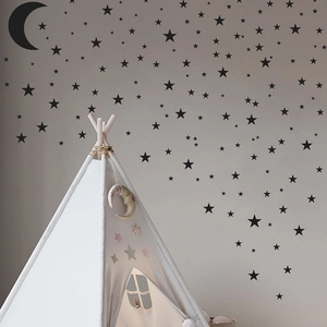 Nahaufnahme von schwarzen Mond und Sterne Wandtattoos in einem gemütlichen Kinderzimmer