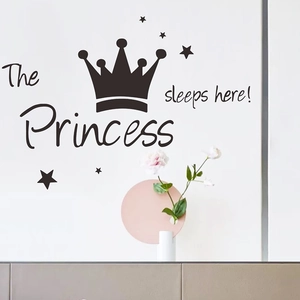 Détail du sticker mural 'The Princess sleeps here' avec couronne et étoiles sur mur blanc