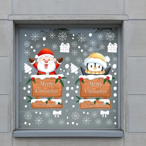 Christmas wall stickers set featuring Santa, penguins, and snowflakes on a glass window