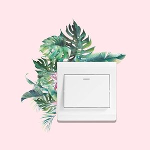 Interrupteur blanc minimaliste avec décor de feuilles vertes sur fond rose tendre