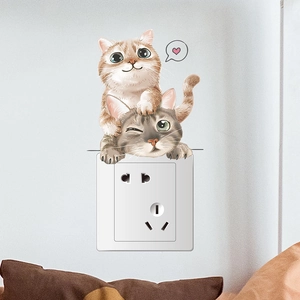 Gros plan de stickers muraux chats mignons posés sur une prise blanche pour chambre d'enfant