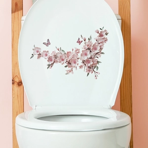 Watercolor pink cherry blossom and butterfly wall sticker applied on white toilet lid