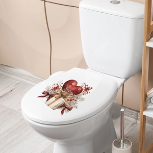 Close-up of heart and gift box wall decals on a white toilet in a cozy bathroom setting