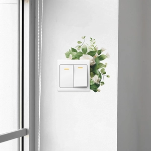Detail view of fresh green botanical wall stickers on a standard double light switch panel