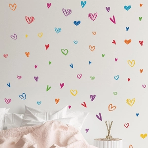 Colorful hand-painted graffiti heart wall stickers set in a cozy minimalist bedroom scene