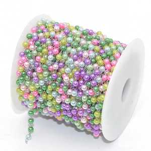 Colorful faux pearl bead chain with silver links on a white plastic spool for DIY jewelry